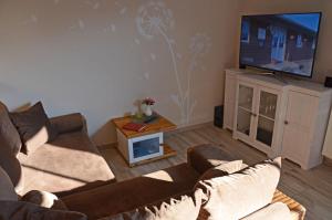 a living room with a couch and a flat screen tv at Bella Casa 36 - Mones in Juliusruh