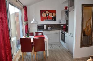 a kitchen with a table and chairs and a kitchen with a window at Bella Casa 36 - Mones in Juliusruh