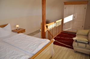 a bedroom with a bed and a chair and a staircase at Bella Casa 36 - Mones in Juliusruh