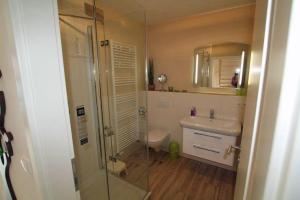 a bathroom with a shower and a toilet and a sink at Bella Casa 36 - Mones in Juliusruh +10 photos