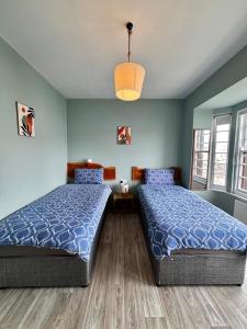 two beds in a room with blue walls at Strandhill Guesthouse in Sligo