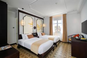 a hotel room with two beds and a television at Royal Riverside Hoi An Hotel-Newly Renovated & Reopened in Hoi An +64 photos
