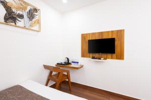 a room with a bed and a tv on a wall at FLY VIEW Airport Residency in Nedumbassery