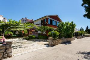 a house with a garden in front of it at Apartments Lovorik in Krk