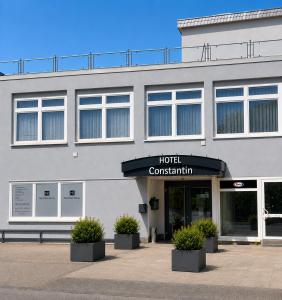ein Hotelgebäude mit Topfpflanzen davor in der Unterkunft Hotel Constantin Trier in Trier