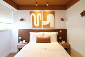 a bedroom with a large bed with a wooden headboard at Tinico's Guest Rooms in Nazaré