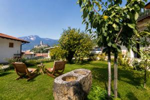 a yard with two chairs and a table and a tree at Casa Palmira in Drena