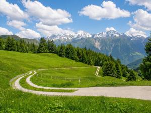 a winding road on a hill with mountains in the background at Casa Vista Adula, Unplug everything, breathe in Anvéuda +13 photos