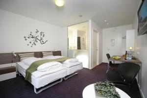 スラーエルセにあるOnlySleep Oksebrovejのベッド、テーブル、椅子が備わるホテルルームです。