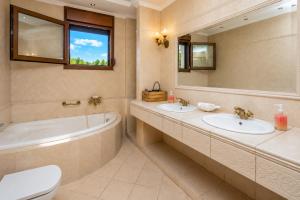 a bathroom with two sinks and a tub and a toilet at Suite Acropolis Serres Parking EV Next to Center in Serres +30 photos