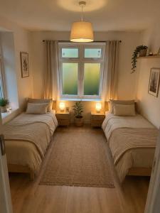 two beds in a room with a window and a rug at Lake House in Mühlehorn