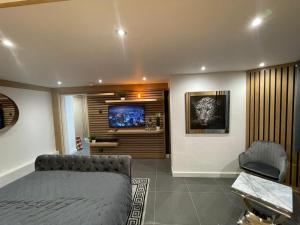 a bedroom with a bed and a tv on a wall at Hendham House - Near Etihad Stadium, CoOp Live Arena, AO Arena, Piccadilly Train Station & Manchester City Centre in Manchester +94 photos