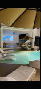 a swimming pool in a house with an umbrella at Grand De Raj in Angeles