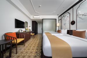 a hotel room with two beds and a desk at Royal Riverside Hoi An Hotel-Newly Renovated & Reopened in Hoi An