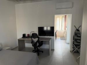 a bedroom with a desk with a television and a chair at Les Maisons Manzoni in Magenta