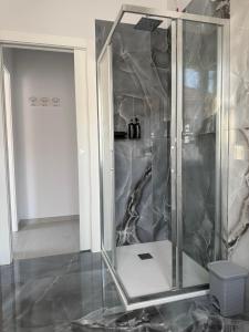 a shower with a glass door in a room at Les Maisons Manzoni in Magenta