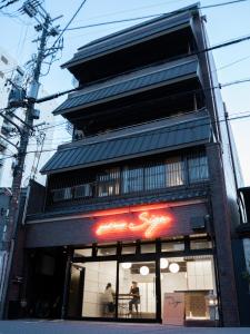 a store front of a building with people in the window at Guesthouse Sign in Kyoto