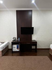 a living room with a flat screen tv on a wall at Grand Turon Plaza Hotel in Tashkent