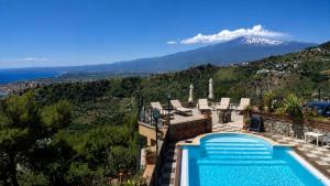 a villa with a swimming pool and a mountain at Sarah apartment in Taormina