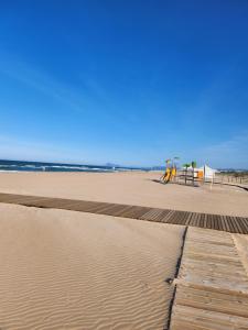 a sandy beach with a bench and a playground at Casa de Panorama in Jeresa