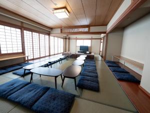 a large room with chairs and tables and a television at Guesthouse Sign in Kyoto