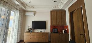 a living room with a television and a wooden cabinet at Huma Living in Vlorë