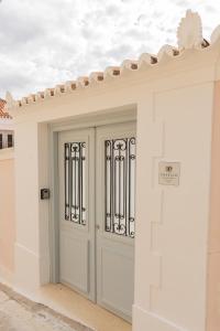 a white garage door with a gate on a building at Emerald Courtyard House in Kranidi