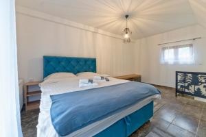 a bedroom with a large bed with a blue headboard at Brvnara Mont 3 in Zlatibor