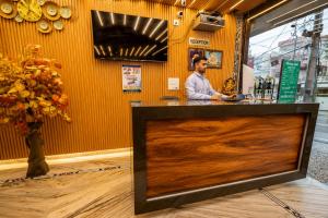 a man is standing behind a counter in a restaurant at Hotel Ganga MBS Rishikesh # Best location # Family Hotel in Rishīkesh