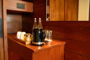 a counter with two bottles of wine and glasses at Mountree Munnar by Kondody Hotels in Anachal