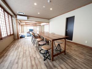 a long conference room with a long table and stools at Guesthouse Sign in Kyoto