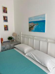 a bedroom with two white beds and a blue floor at Casa Mamà in Marzamemi
