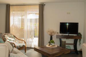 a living room with a tv and a coffee table at Hoeve Hofgaarde in Heers