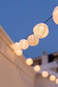 a bunch of lights hanging from a string at Emerald Courtyard House in Kranidi +12 photos