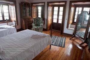 a bedroom with a bed and a chair and windows at Quinta Santo António in Sintra