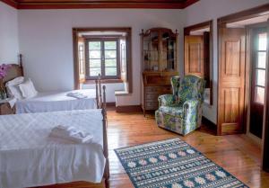 a bedroom with a bed and a chair and a window at Quinta Santo António in Sintra