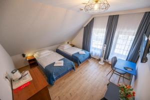 a small room with two beds and a chair at Apartamenty Pod Lwem in Świdnica