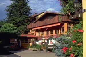 a large wooden building with flowers in front of it at Hotel Altenberg in Baden-Baden