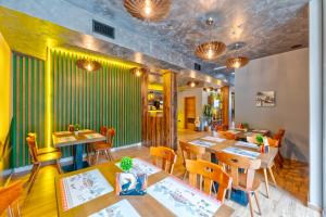 a restaurant with wooden tables and chairs and green walls at Brvnara Mont 3 in Zlatibor