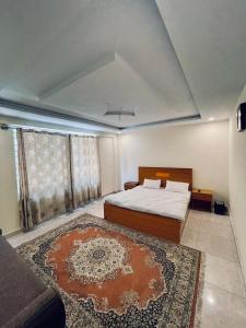 a bedroom with a bed and a couch and a rug at Lee Rivage Inn in Naran