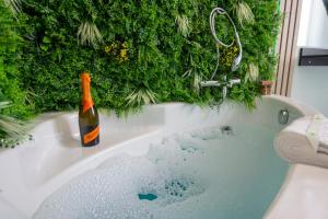 a bottle of champagne sitting on top of a bath tub at Elma Nest in Drobeta-Turnu Severin