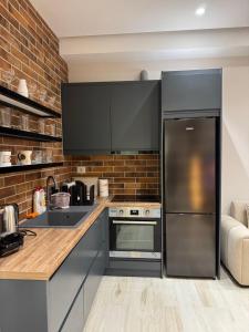 a kitchen with stainless steel appliances and a brick wall at Lost At Sea 2 in Sarandë