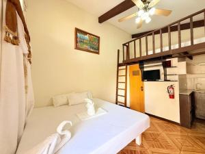 a living room with a white couch and a loft bed at Cocomango's Resort in Taporok