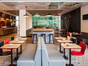 a restaurant with tables and chairs and a bar at ibis Juiz de Fora in Juiz de Fora
