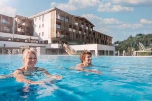 two women in the swimming pool at a hotel at Das Hohe Salve Sportresort, 4 Sterne Superior in Hopfgarten im Brixental