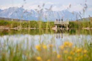 a group of people standing on a bridge over a lake at Das Hohe Salve Sportresort, 4 Sterne Superior in Hopfgarten im Brixental