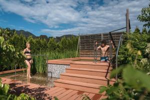 two people in bathing suits standing on a wooden deck at Das Hohe Salve Sportresort, 4 Sterne Superior in Hopfgarten im Brixental +98 photos