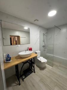 a bathroom with a sink and a toilet and a mirror at Lost At Sea 2 in Sarandë