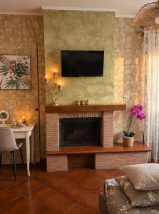 a living room with a fireplace with a flat screen tv at La Mammola Bed&Breakfast in Fabriano