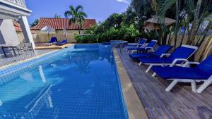 a swimming pool with blue lounge chairs next to it at Serenity by Peace Garden, Koh Samui in Bangrak Beach